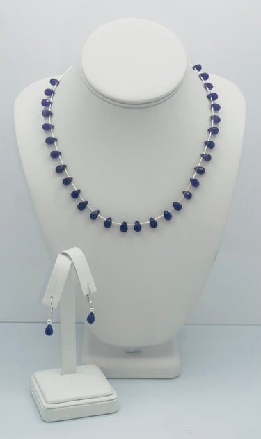 An image of a Fierce Amethyst Briolette Jewelry Set displayed on a mannequin. The set includes a necklace with a series of amethyst briolettes and a pair of hinge-back earrings with additional amethyst briolettes.